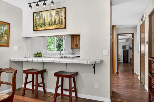 a kitchen with stainless steel appliances a dining table chairs and wooden floor
