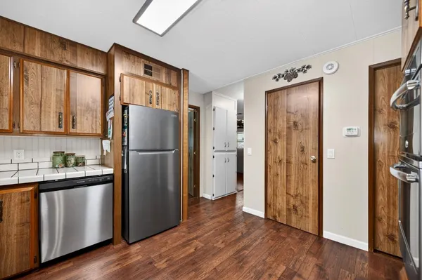 a kitchen with stainless steel appliances granite countertop a refrigerator and a stove top oven