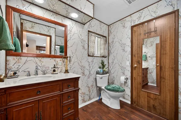 a bathroom with a toilet a sink and a mirror
