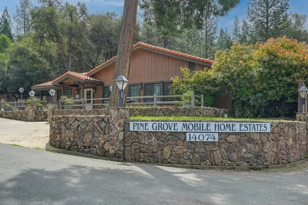 a view of house with sign board and yard