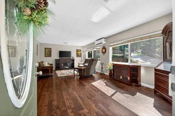 a living room with furniture a fireplace a flat screen tv and a large window