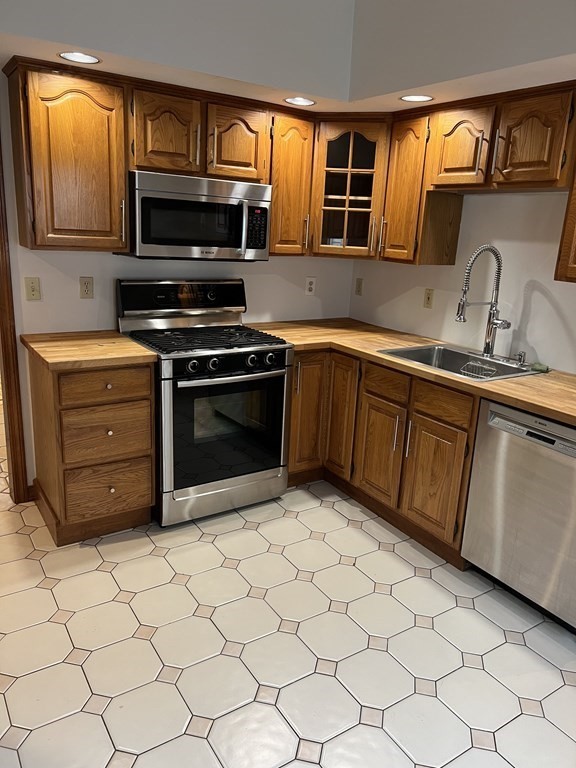 a kitchen with stainless steel appliances a stove a sink and a microwave