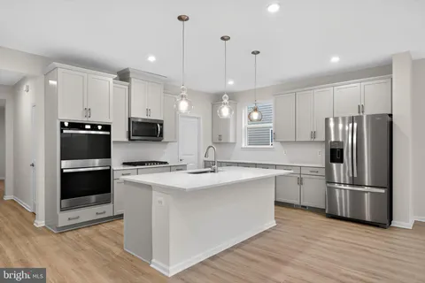a kitchen with kitchen island white cabinets and stainless steel appliances