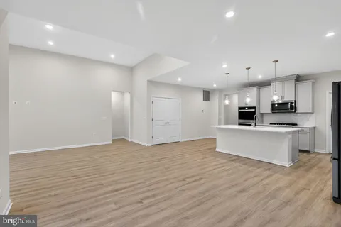 a large kitchen with stainless steel appliances kitchen island a large counter top and a stove top oven