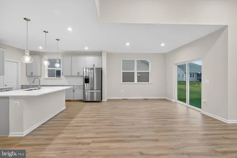 a large kitchen with stainless steel appliances kitchen island a large counter top and a wooden floors
