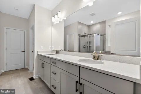 a bathroom with double vanity sinks and a mirror
