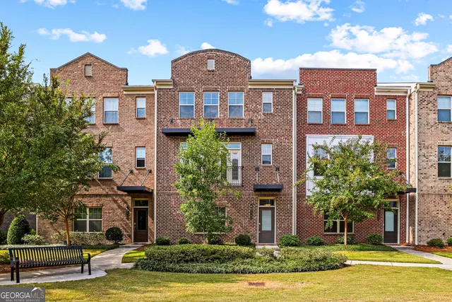 a front view of a building with a garden and plants