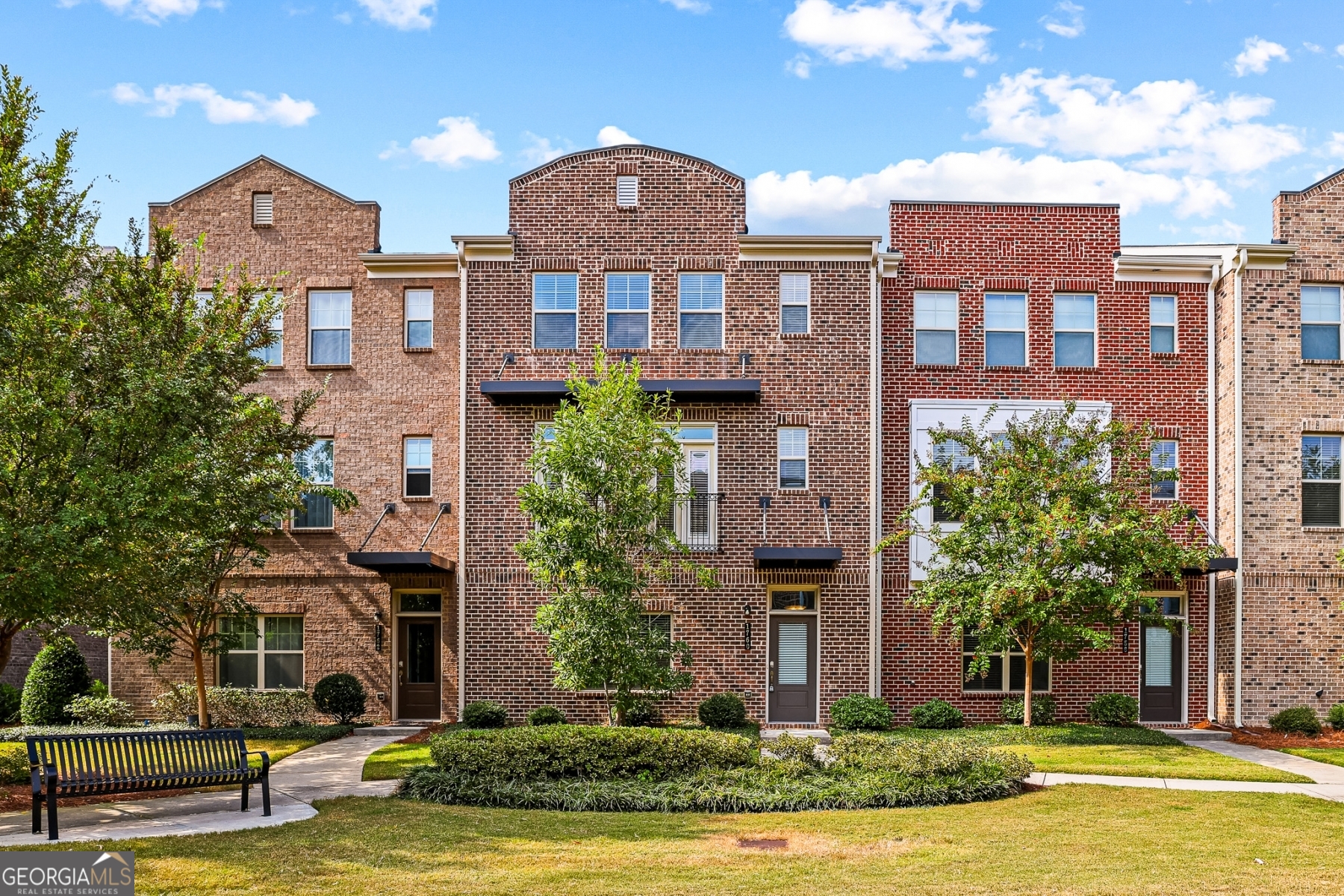 a front view of a building with a garden and plants