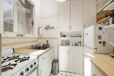 a kitchen with kitchen island a sink stove and refrigerator