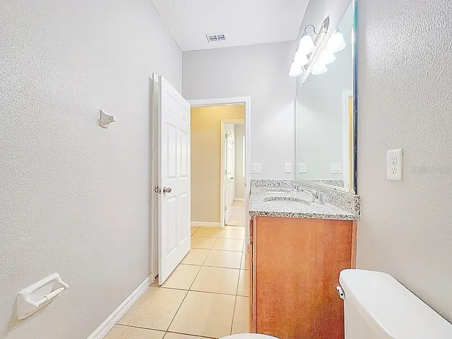 a bathroom with a granite countertop sink a toilet and shower