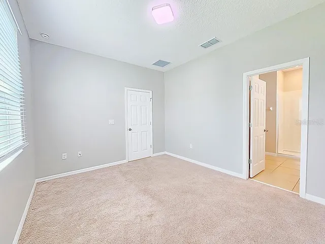 an empty room with windows and closet