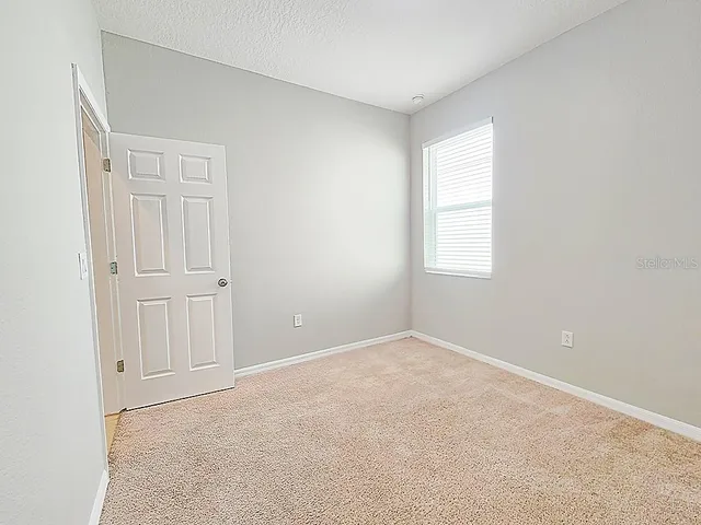 an empty room with windows and closet