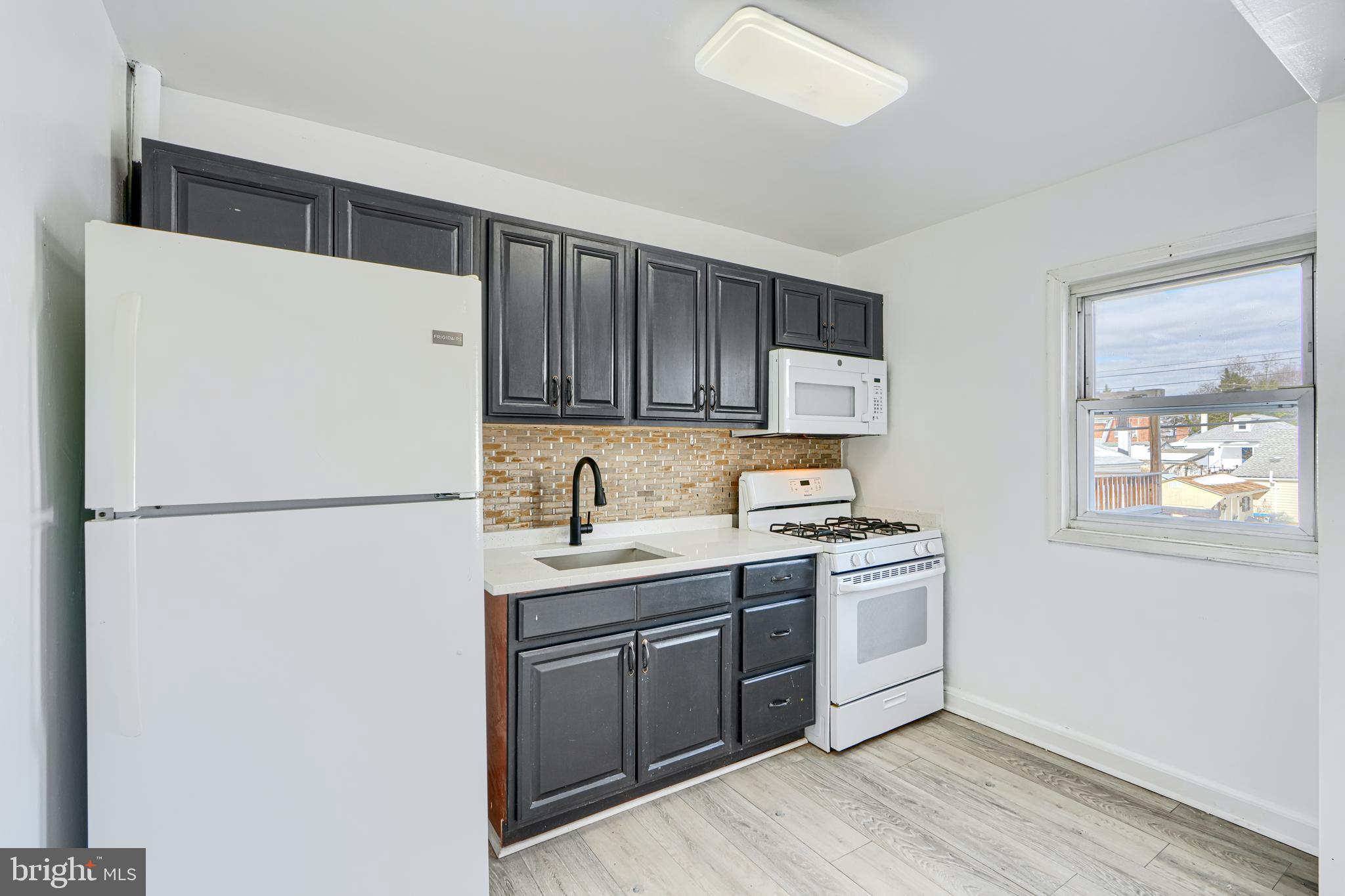 165 Hampshire Road Essex, MD 21221 - Photo 11 of 40 a kitchen with a refrigerator sink and cabinets