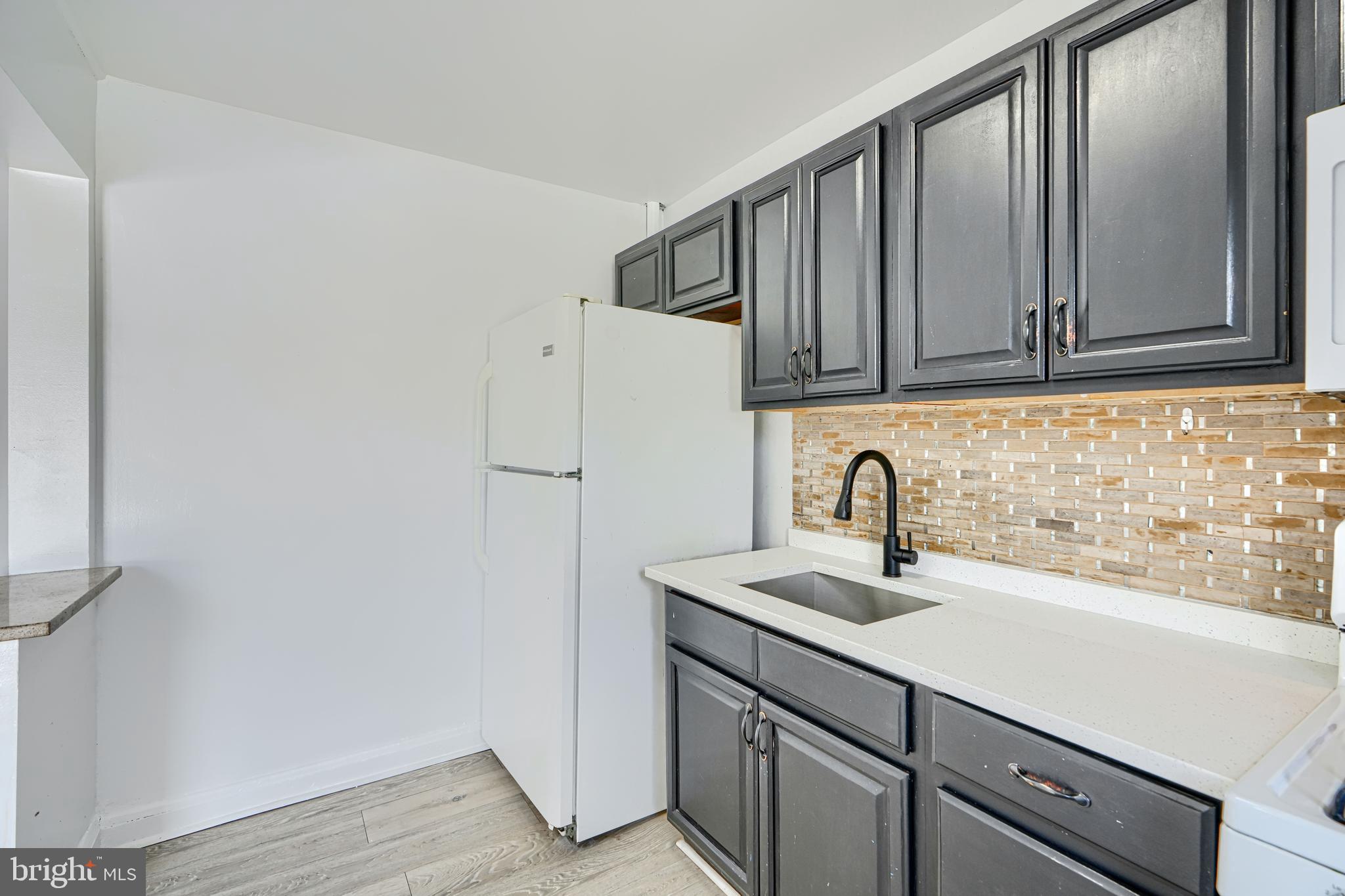 165 Hampshire Road Essex, MD 21221 - Photo 12 of 40 a kitchen with a sink cabinets and wooden floor