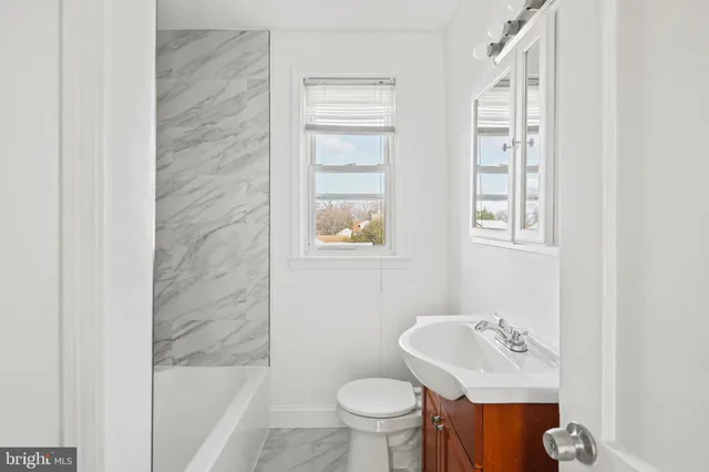 an empty room with a window and ceiling fan