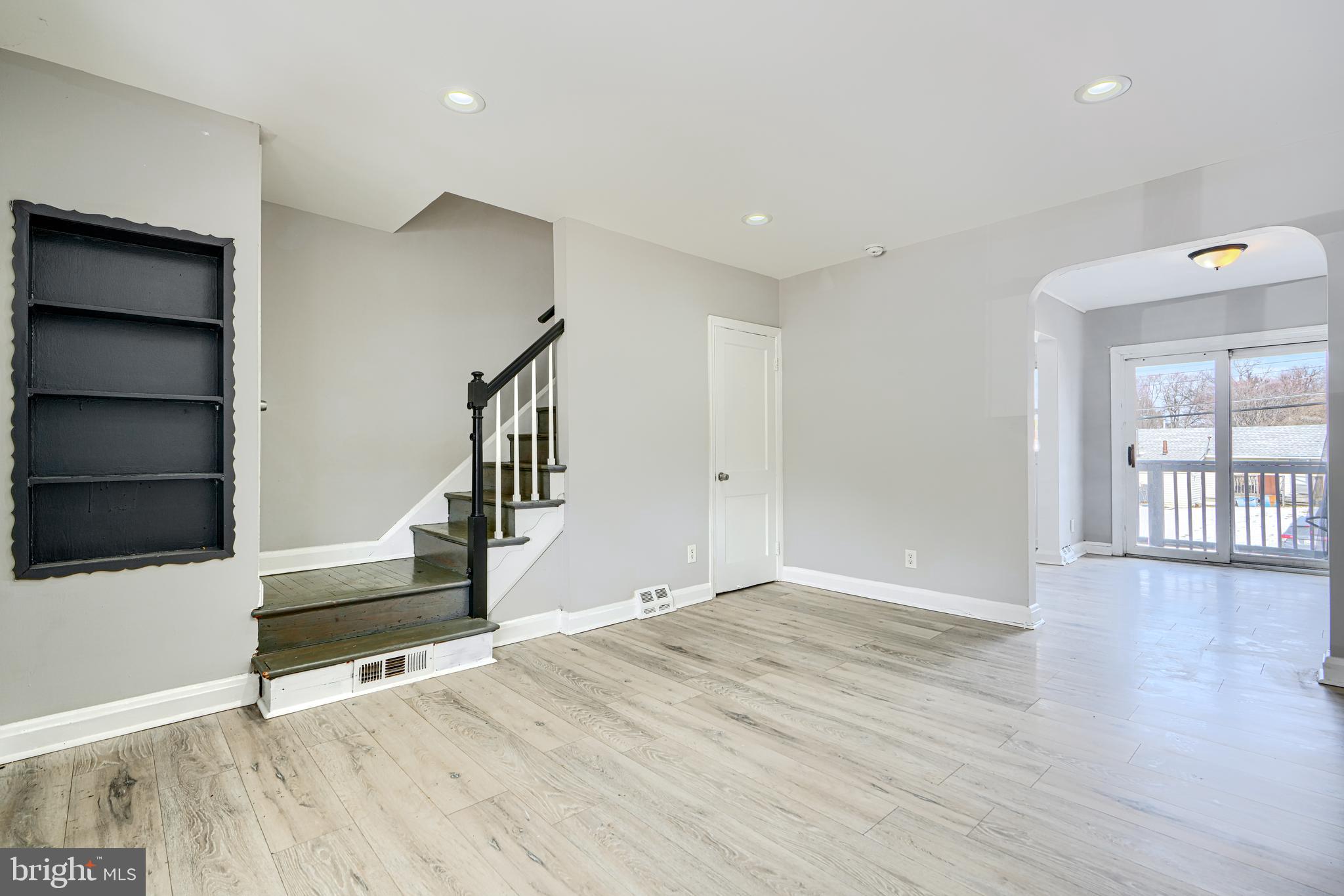 165 Hampshire Road Essex, MD 21221 - Photo 5 of 40 a view of an empty room with wooden floor and staircase
