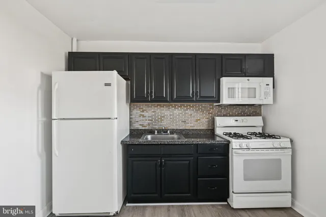 a kitchen with stainless steel appliances granite countertop a sink stove and microwave