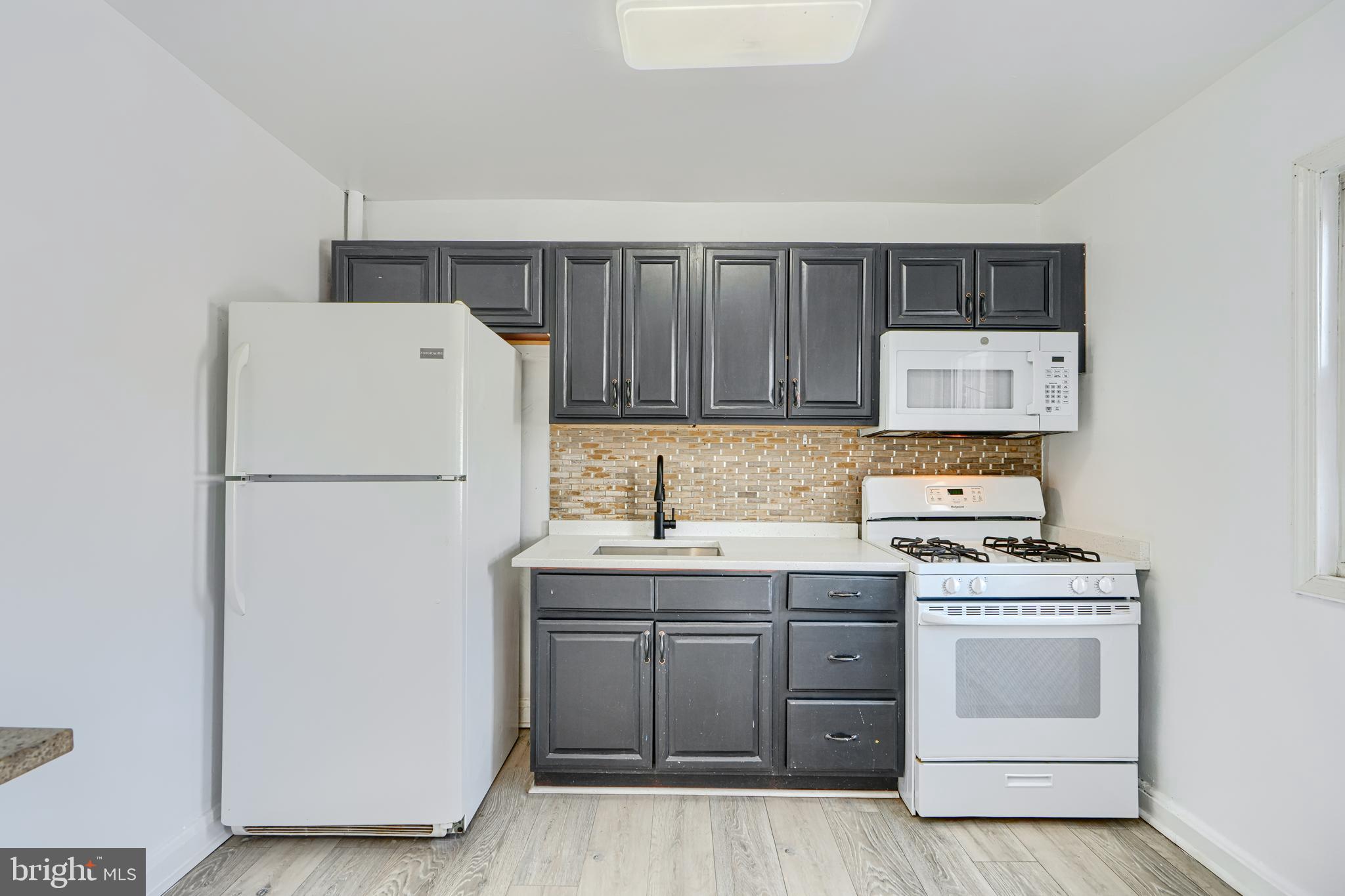 165 Hampshire Road Essex, MD 21221 - Photo 10 of 40 a kitchen with a stove sink and refrigerator