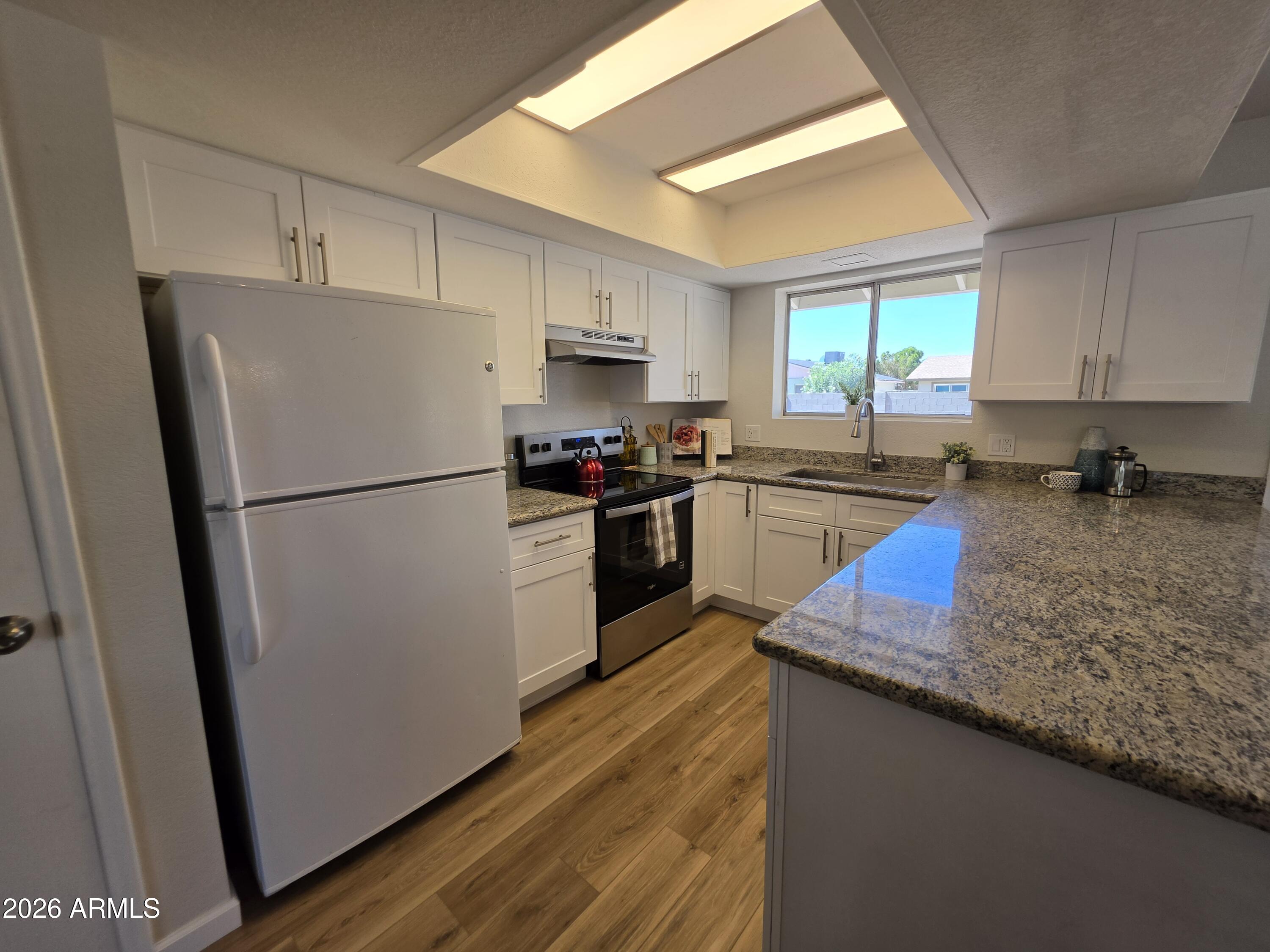 46 East McLellan Road Mesa, AZ 85201 - Photo 5 of 18 a kitchen with granite countertop a refrigerator a sink dishwasher a stove top oven a refrigerator and cabinets