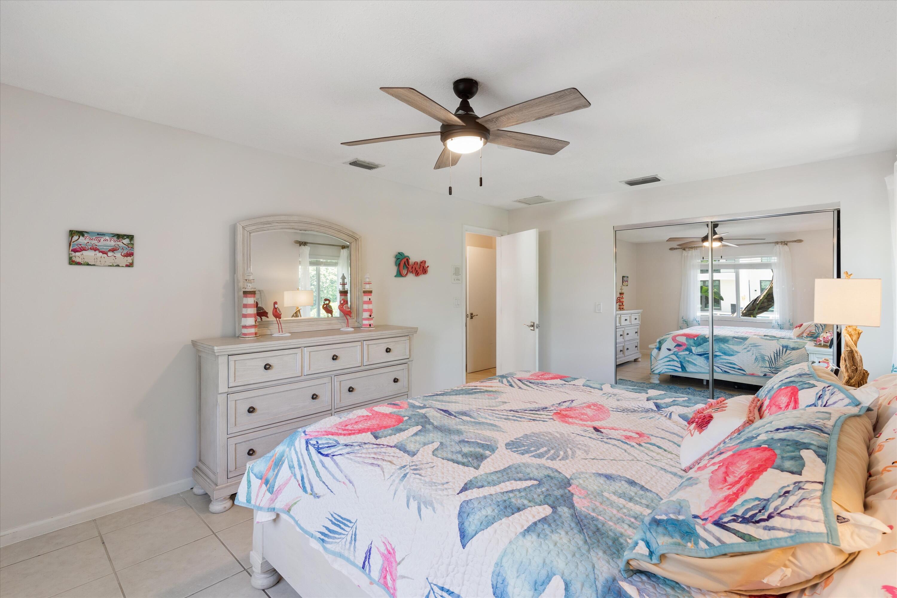 830 Northeast Boca Bay Colony Drive Boca Raton, FL 33487 - Photo 32 of 52 a bedroom with a bed and a dresser in it