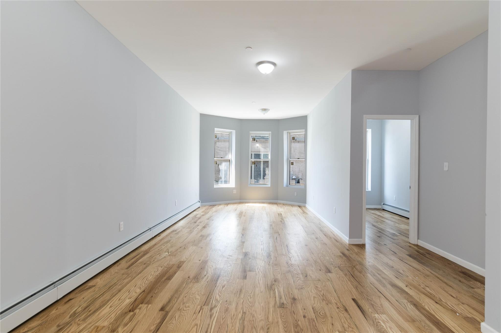 1102 Jackson Avenue Bronx, NY 10456 - Photo 12 of 36 wooden floor in an empty room with a window