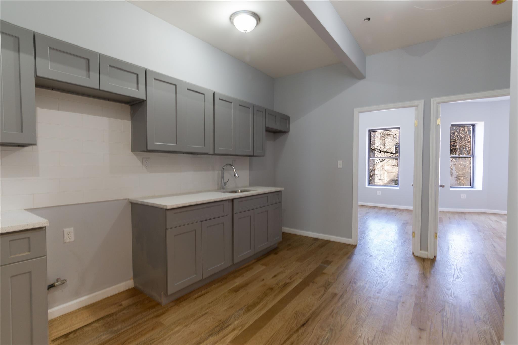 1102 Jackson Avenue Bronx, NY 10456 - Photo 14 of 36 a kitchen with wooden floors and cabinets