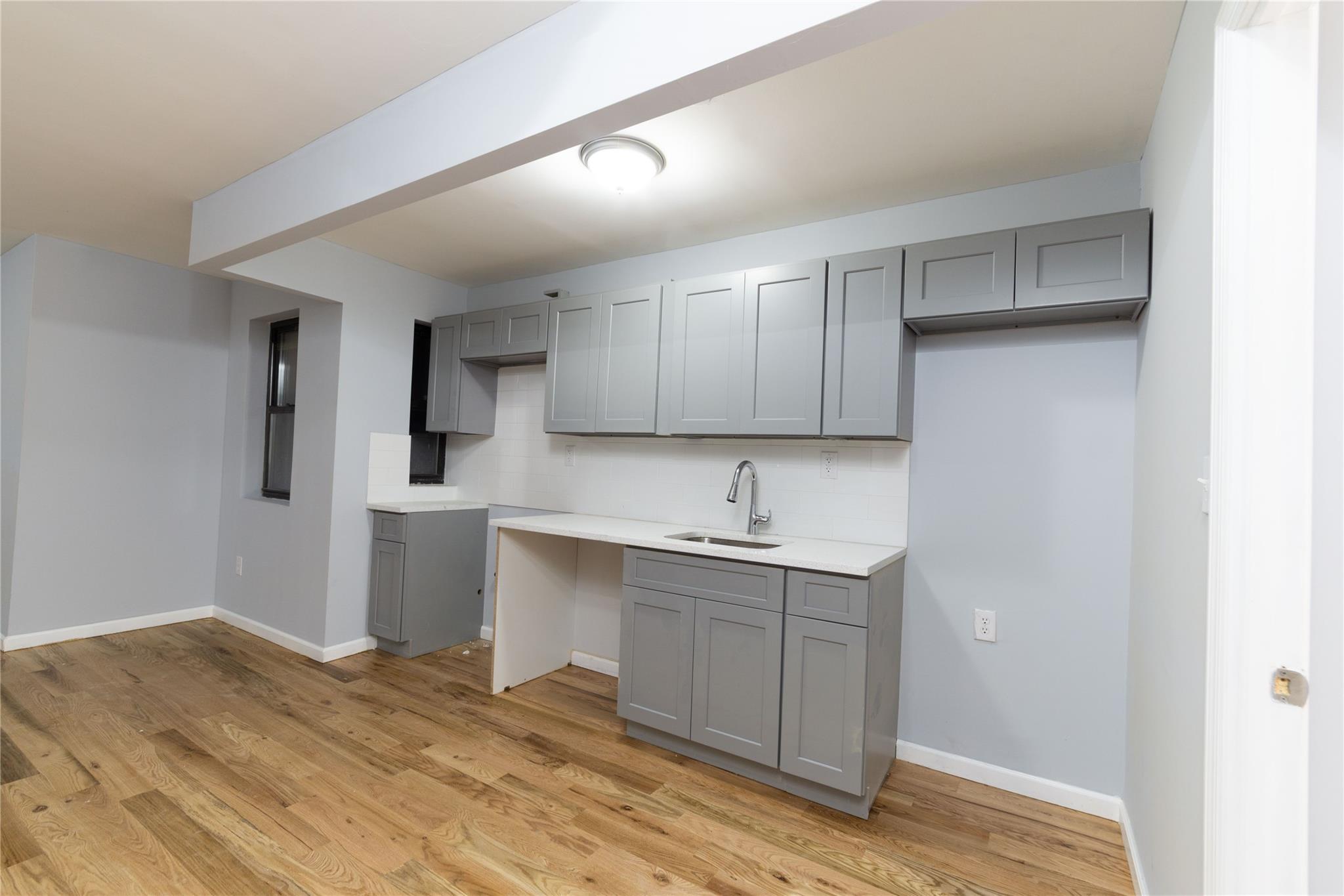 1102 Jackson Avenue Bronx, NY 10456 - Photo 29 of 36 a kitchen with a sink cabinets and wooden floor