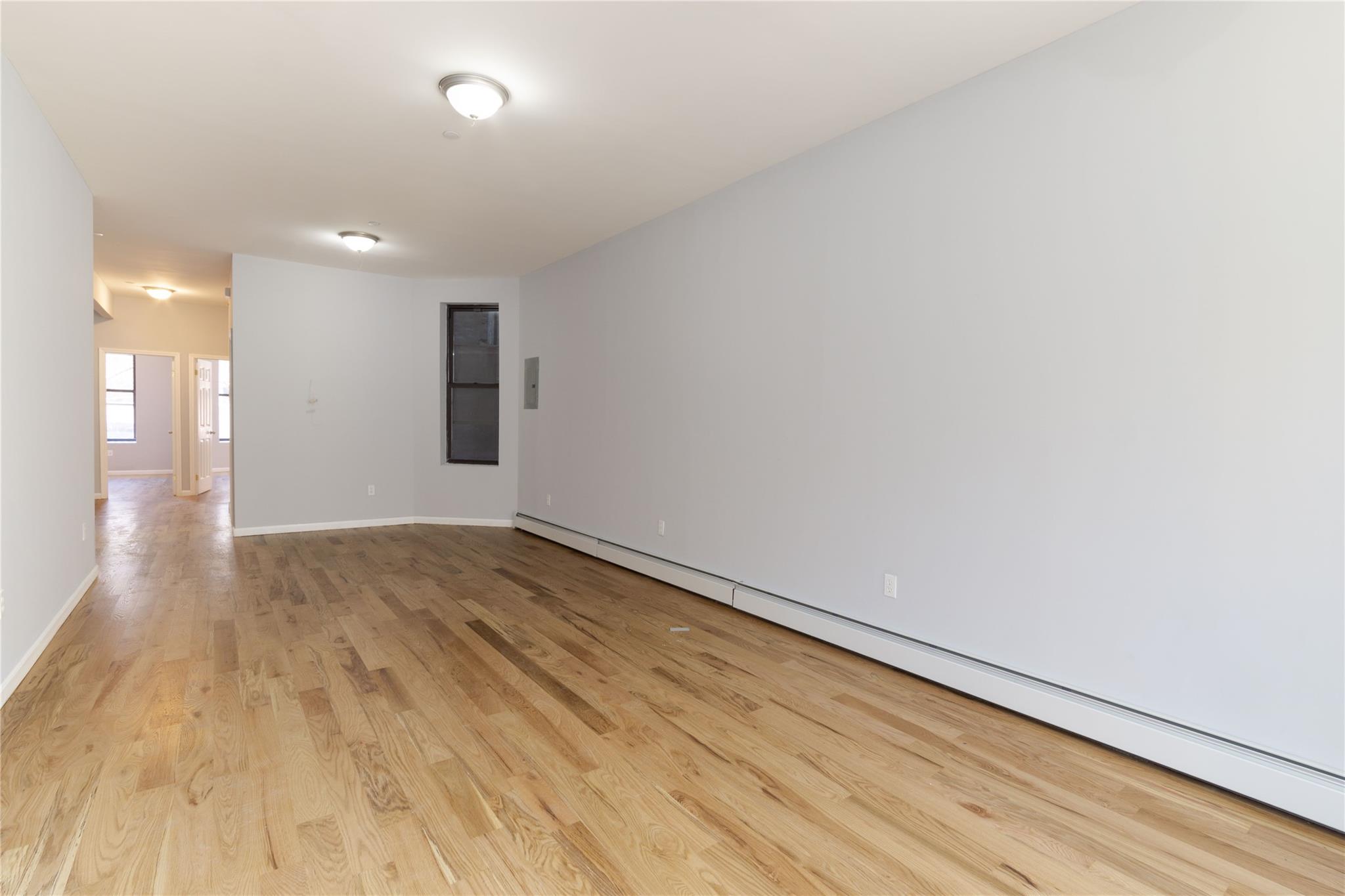 1102 Jackson Avenue Bronx, NY 10456 - Photo 3 of 36 a view of an empty room and wooden floor