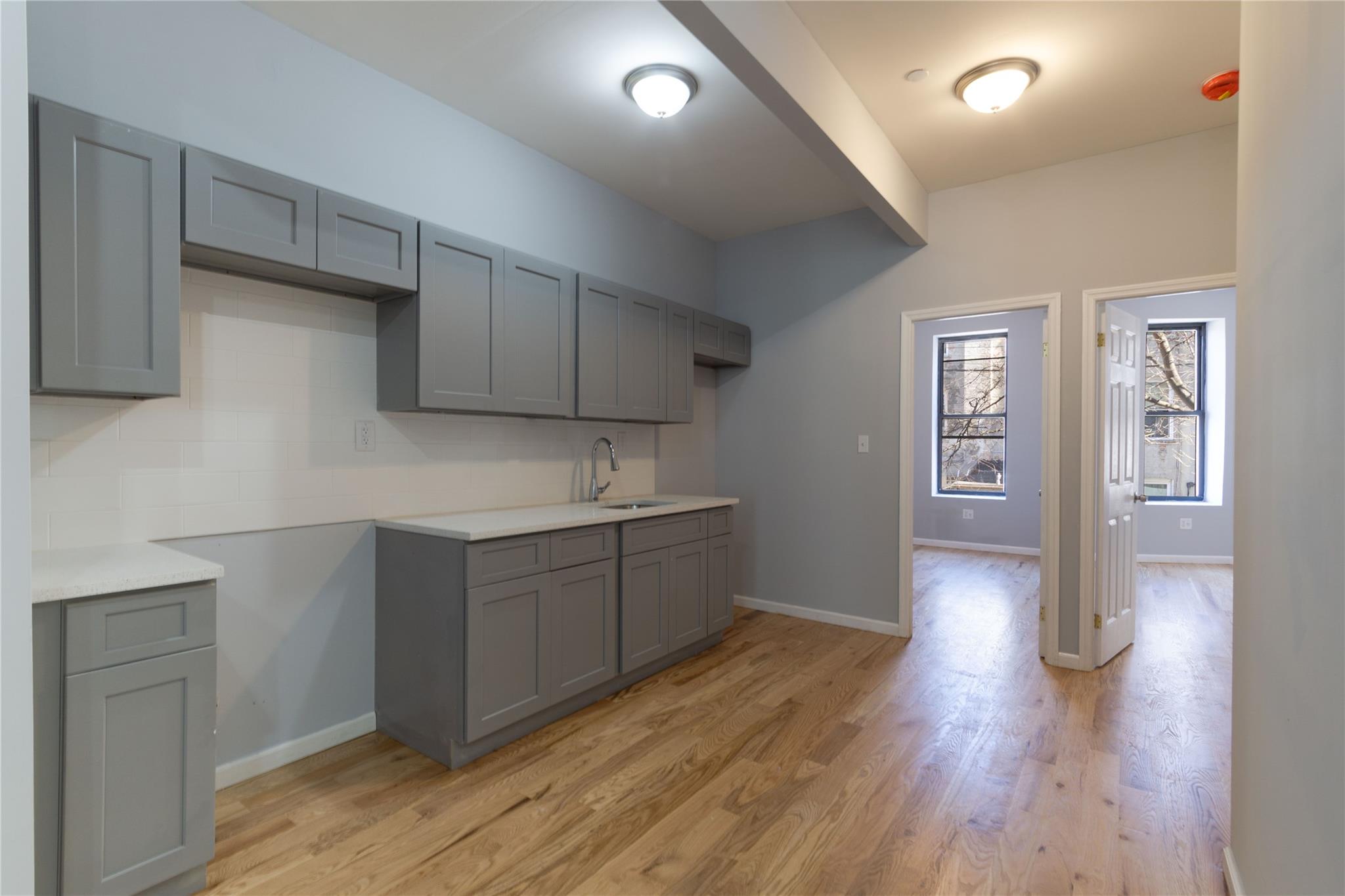1102 Jackson Avenue Bronx, NY 10456 - Photo 4 of 36 a kitchen with sink cabinets and wooden floor