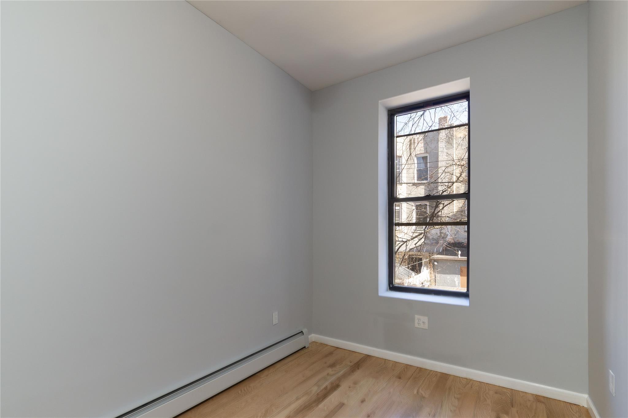 1102 Jackson Avenue Bronx, NY 10456 - Photo 7 of 36 an empty room with a window