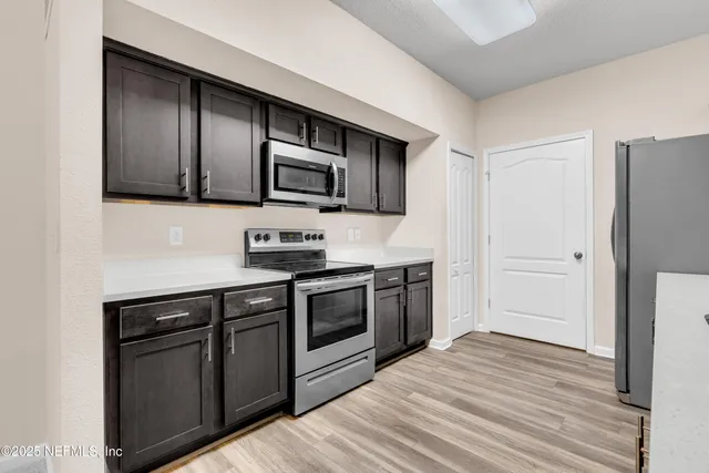 a kitchen with stainless steel appliances granite countertop a stove microwave and refrigerator