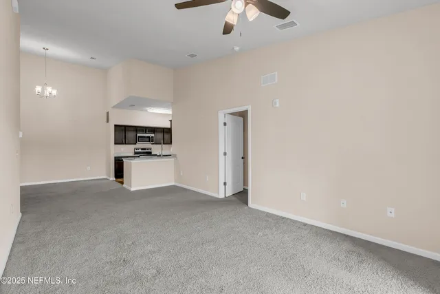 a view of kitchen with cabinets and refrigerator
