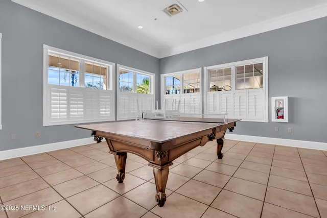 a living room with couches a coffee table and kitchen view with wooden floor