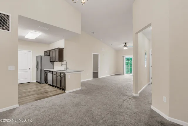 a view of a kitchen with stainless steel appliances a refrigerator and a sink