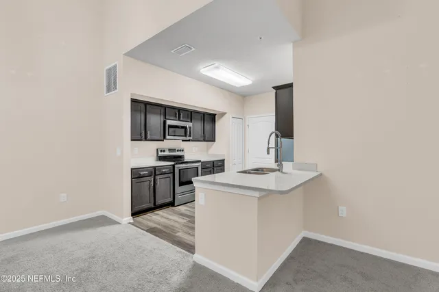 a kitchen with a sink a stove top oven and stainless steel appliances