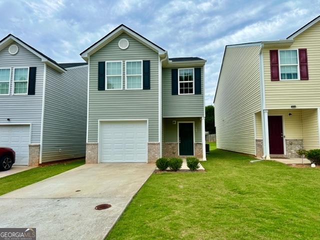 a front view of a house with a yard and garage
