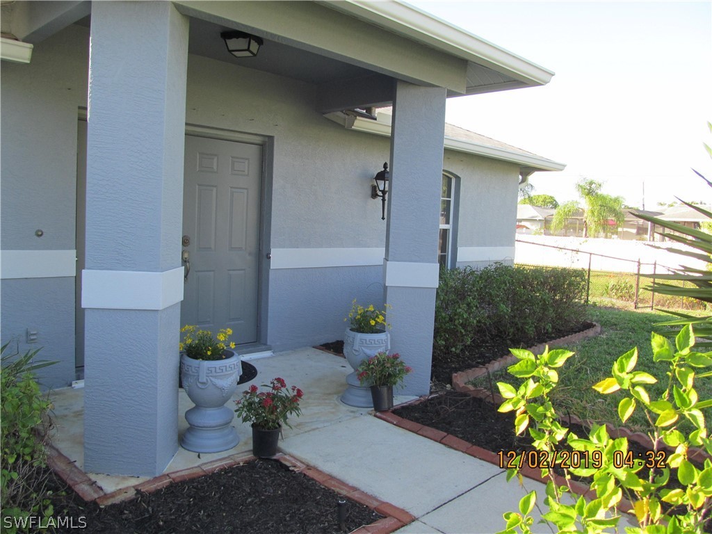 17532 Butler Road Fort Myers, FL 33967 - Photo 4 of 29 a front view of a house with a flower garden