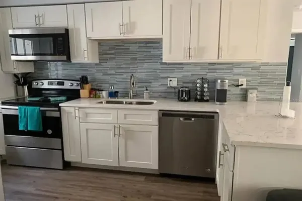 a kitchen with stainless steel appliances granite countertop a sink stove and cabinets