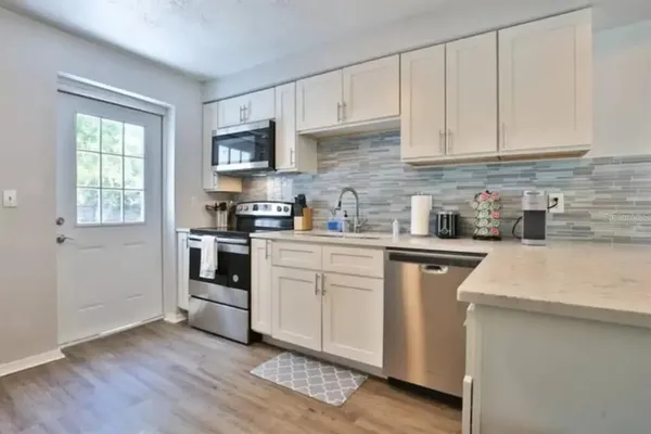 a kitchen with granite countertop white cabinets and white appliances