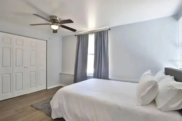 a bedroom with a large bed and a chandelier