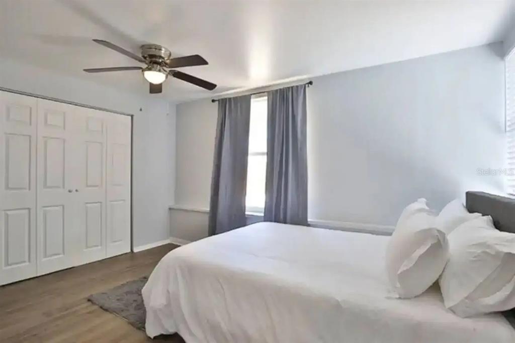 3113 McIntosh Road Sarasota, FL 34232 - Photo 16 of 22 a bedroom with a large bed and a chandelier