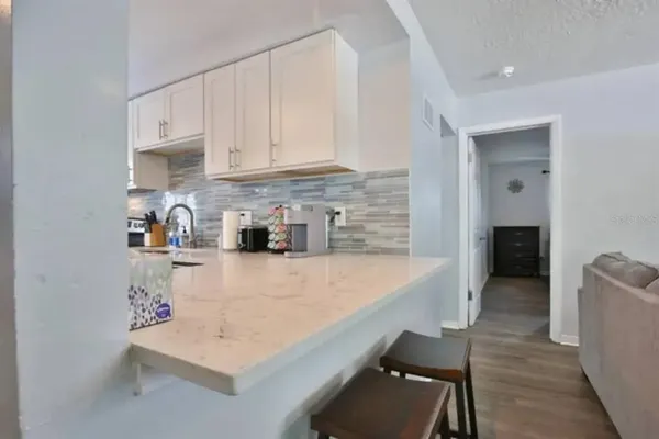 a kitchen with stainless steel appliances granite countertop a sink refrigerator and cabinets