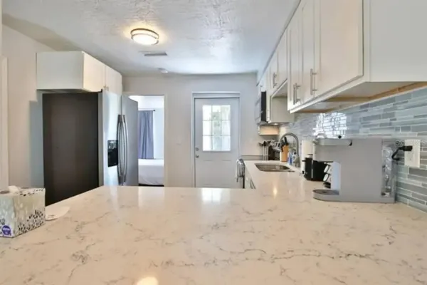 a view of a livingroom with furniture and a kitchen