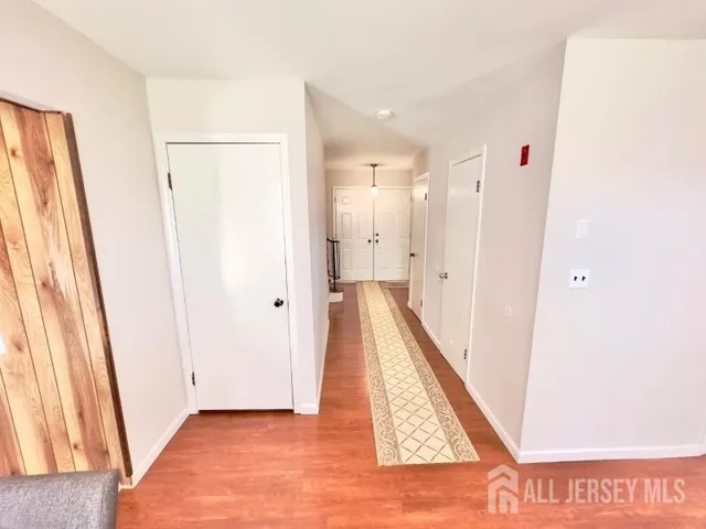 a view of a hallway with wooden floor and staircase