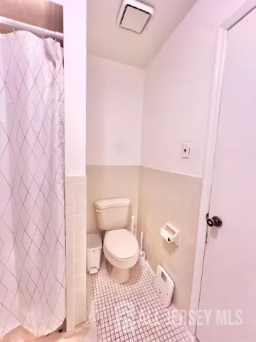 a bathroom with a toilet and a shower curtain