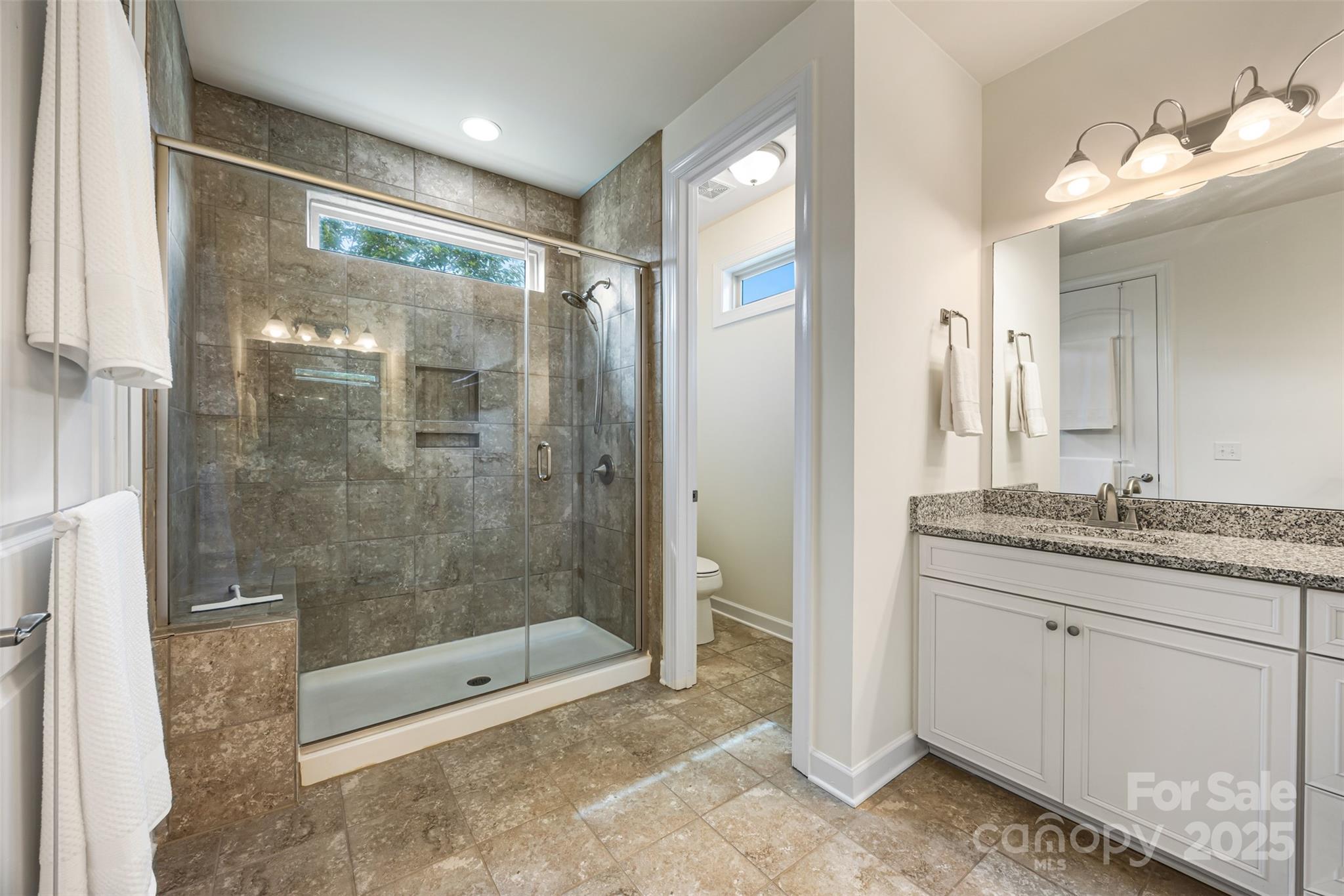 1284 Independence Street Fort Mill, SC 29708 - Photo 18 of 34 a bathroom with a granite countertop sink a mirror and a shower
