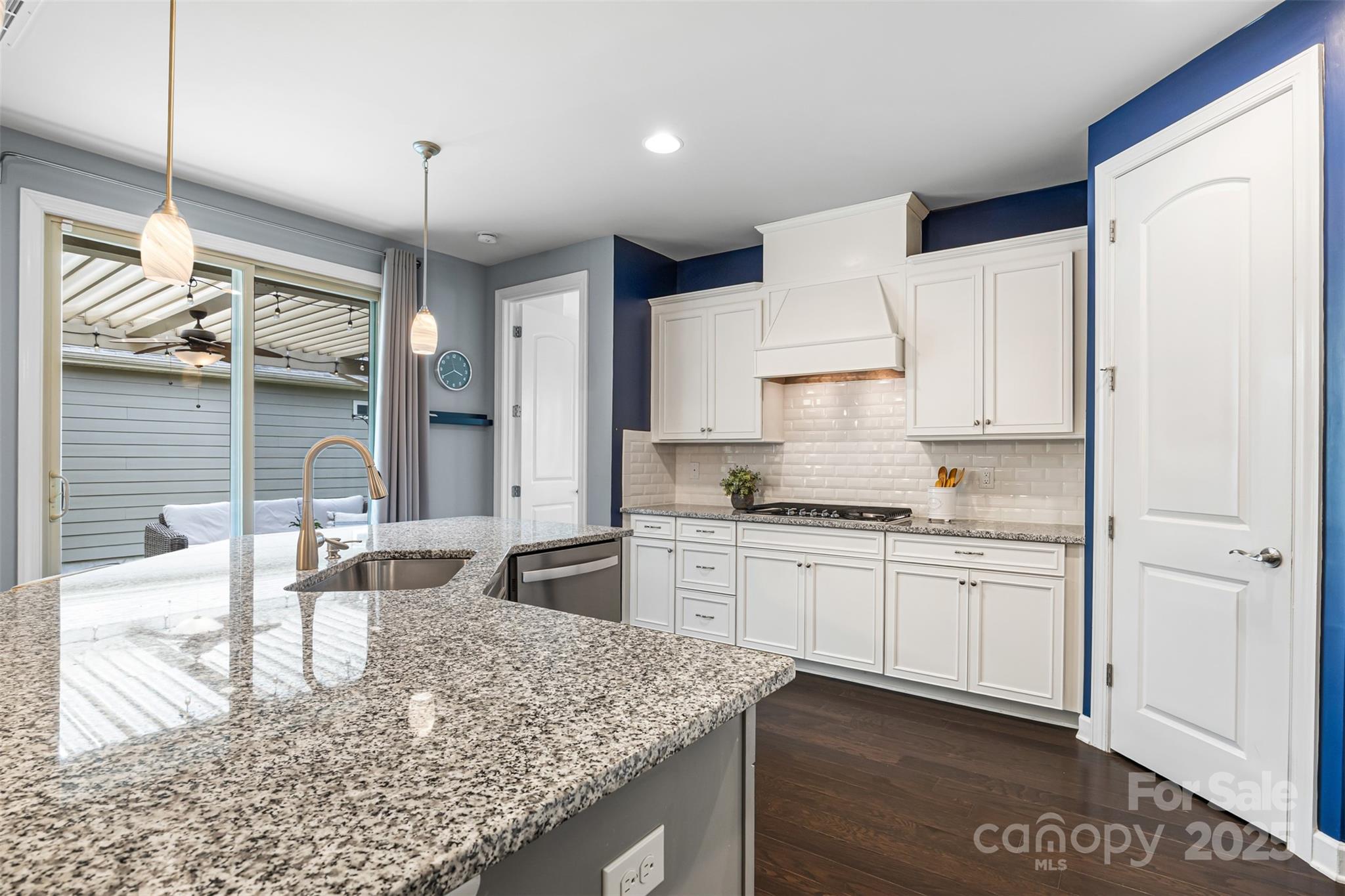 1284 Independence Street Fort Mill, SC 29708 - Photo 10 of 34 a kitchen with kitchen island granite countertop a stove a sink a refrigerator and white cabinets with wooden floor