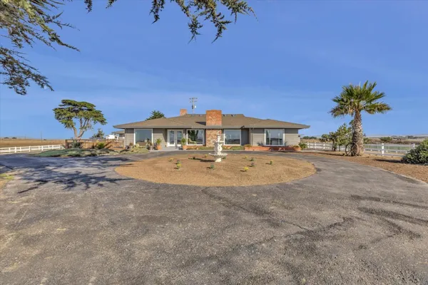a front view of a house with a yard and a garden