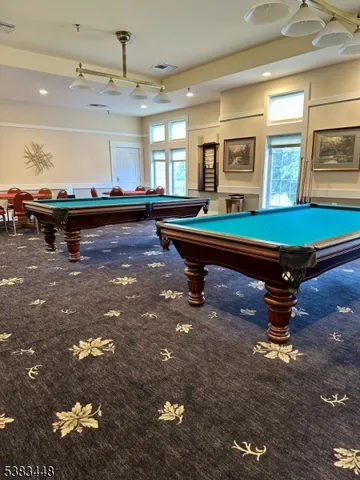 a room with pool table and windows