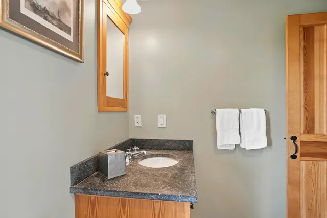 a bathroom with a granite countertop sink and a mirror